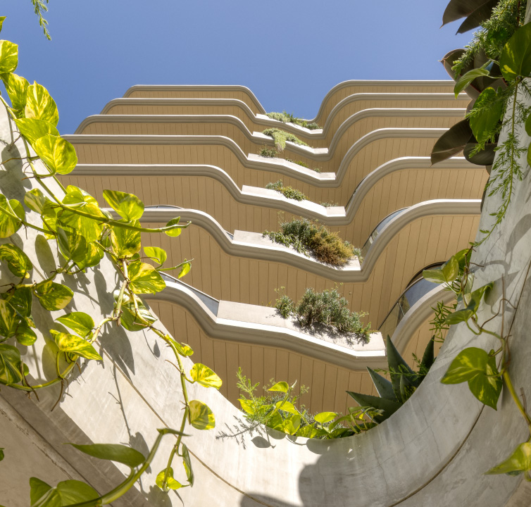 Concrete coloured apartment building taken from below looking up.